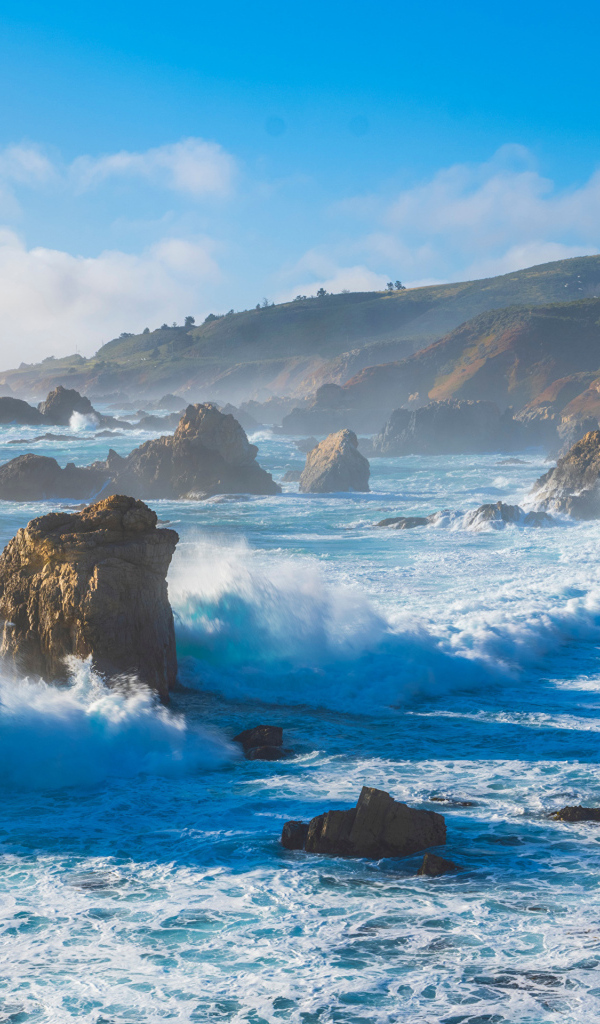 Белые бушующие волны бьются о камни 