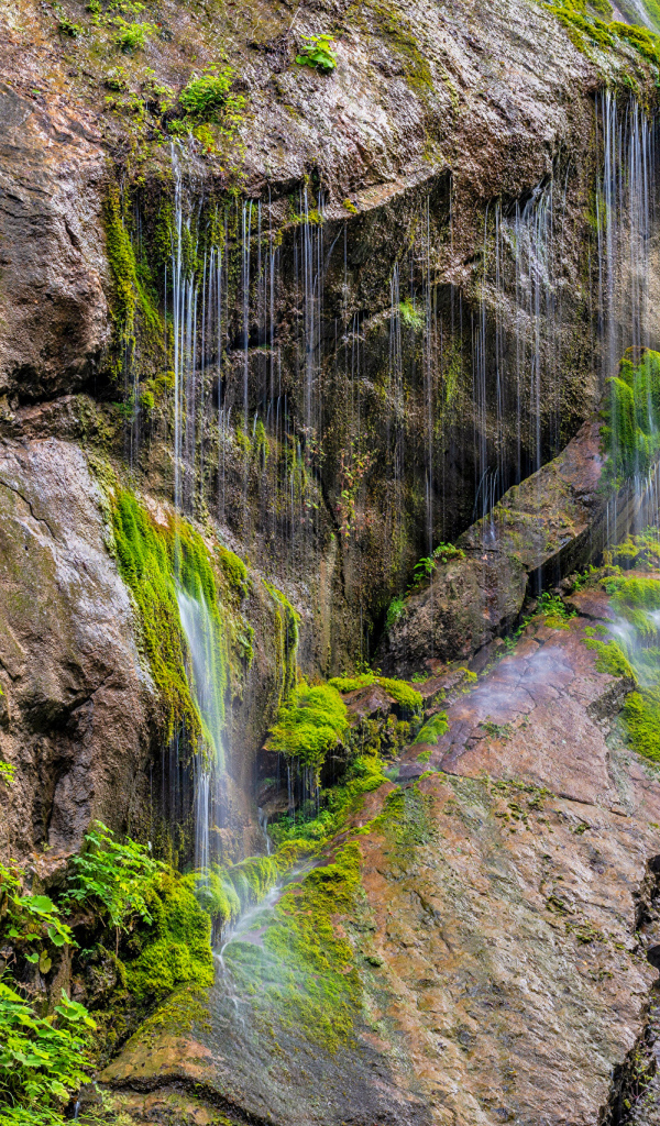 Водопад стекает по большим холодным камнях