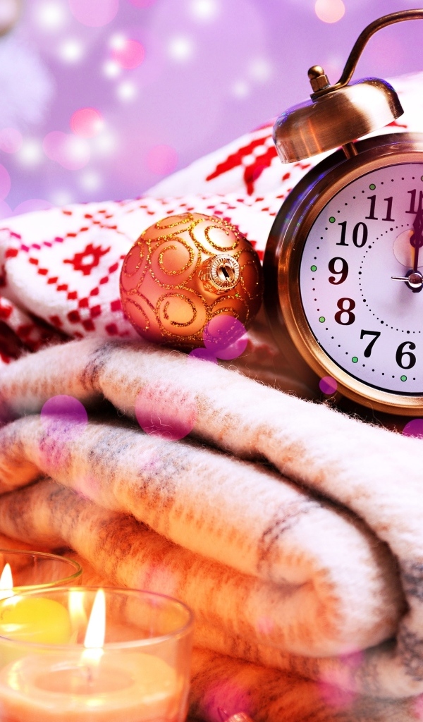 Будильник, теплый плед и зажженные свечи на праздник