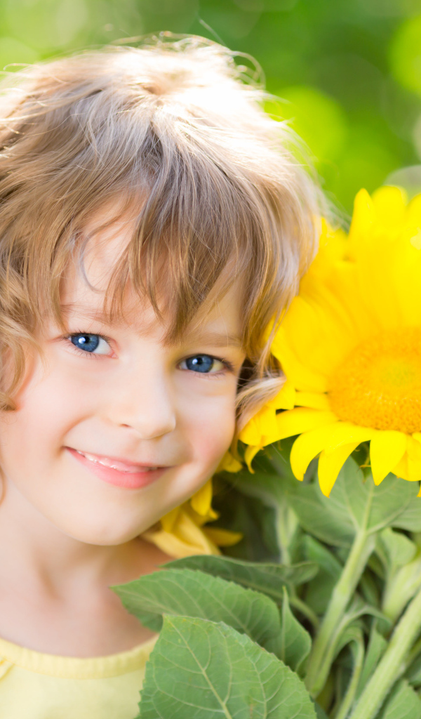 Красивая голубоглазая девочка с букетом подсолнухов