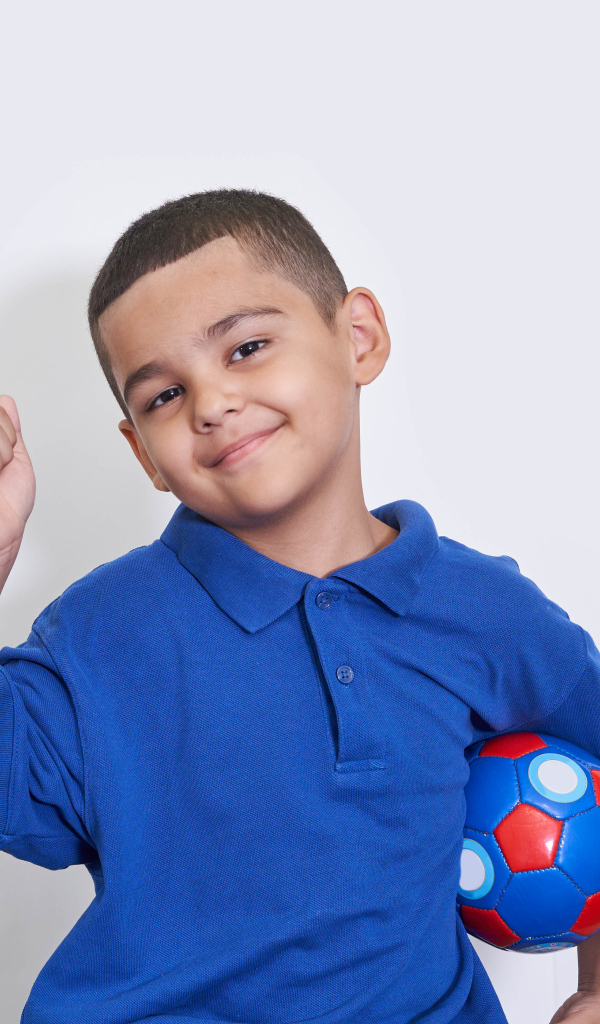 Милый мальчик с мячом на белом фоне