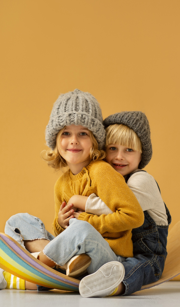 Счастливые брат и сестра в теплых шапках