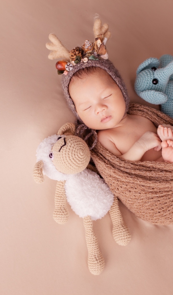 Маленький ребенок в костюме оленя с игрушкой