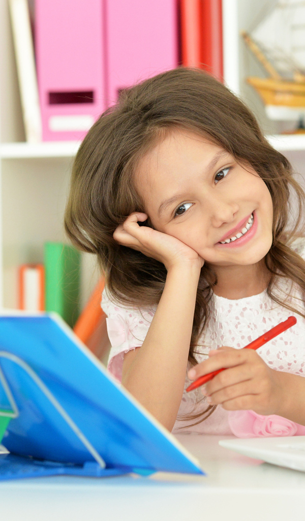 Улыбающаяся школьница делает уроки