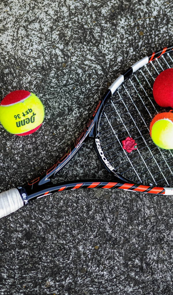 Ракетка и теннисные мячи на черном фоне