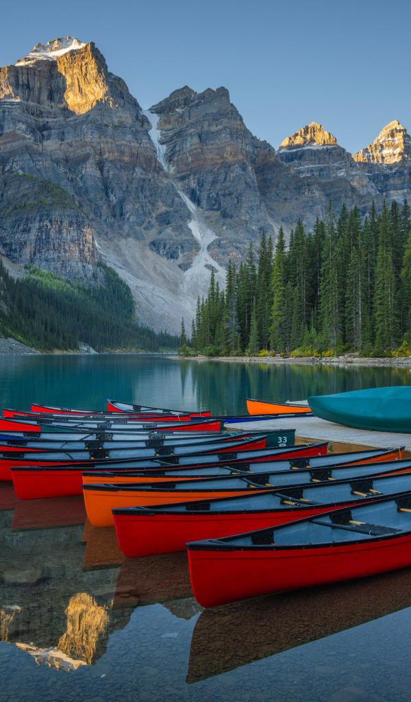 Лодки стоят на берегу у гор, Канада