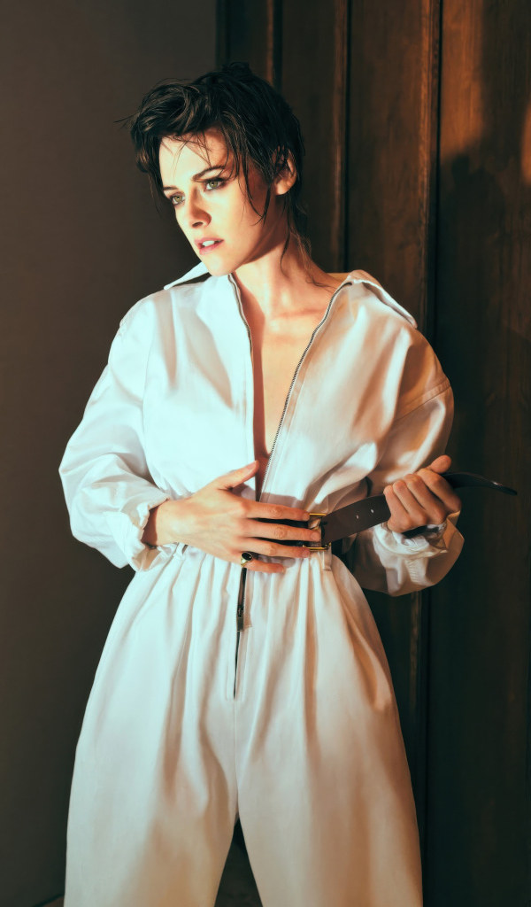 Американская актриса Кристен Стюарт в белом комбинезоне у стены