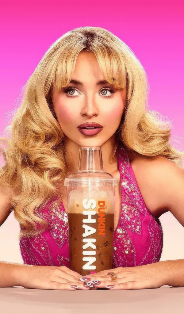 Красивая актриса Сабрина Карпентер пьет напиток на розовом фоне