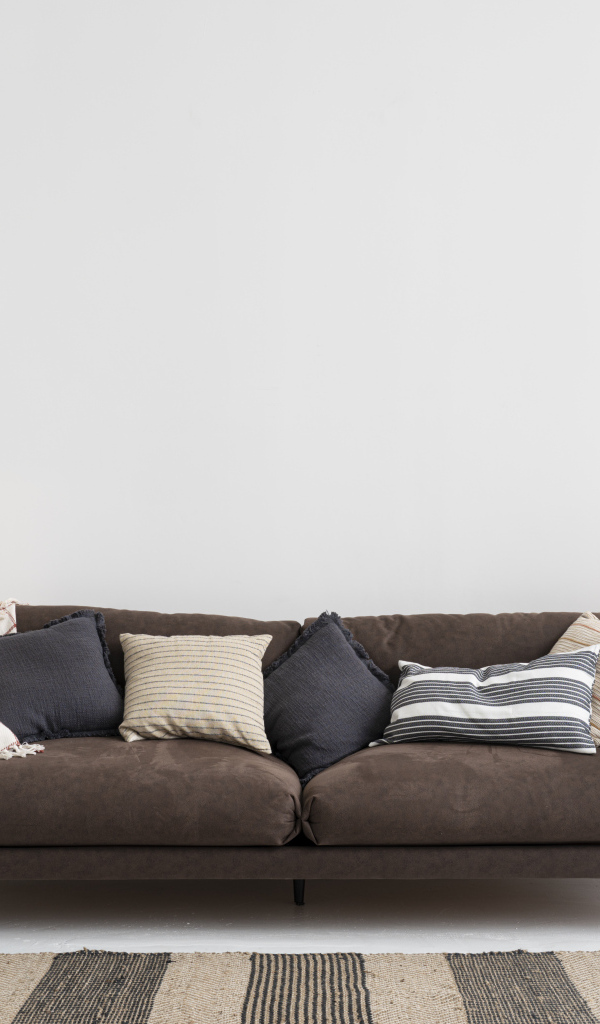 Коричневый диван у серой стены с лампой