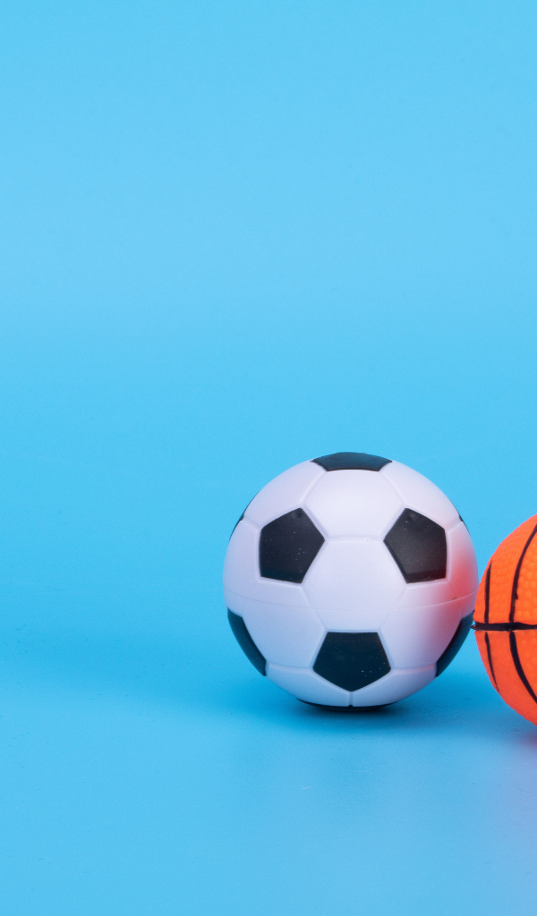 Футбольный и баскетбольный мяч на голубом фоне