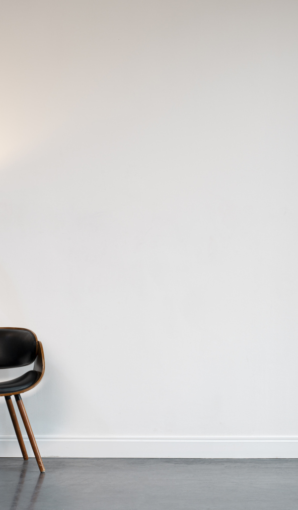 Кожаное кресло с торшером в пустой комнате