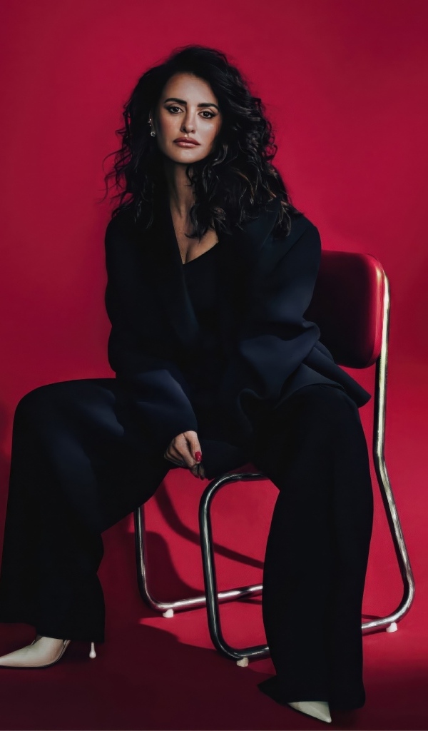 Испанская актриса Пенелопа Крус сидит на стуле на красном фоне