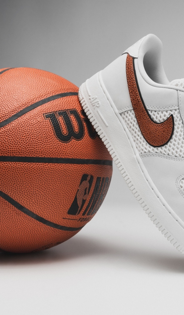 Спортивная обувь и баскетбольный мяч на сером фоне