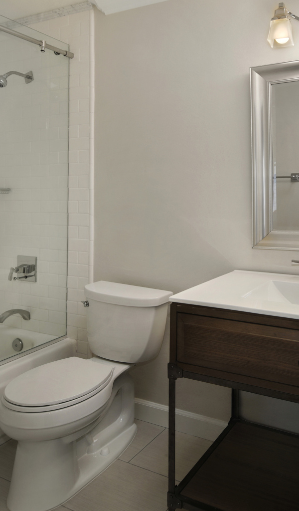 Интерьер ванной комнаты в белом цвете с душевой кабиной и унитазом