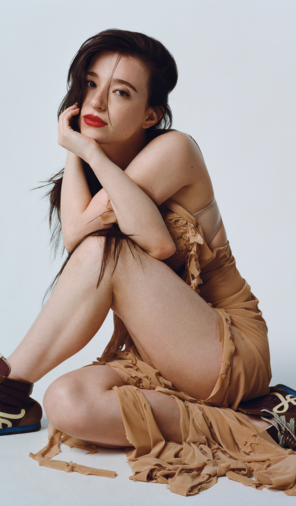 Young actress Mikey Madison on a gray background