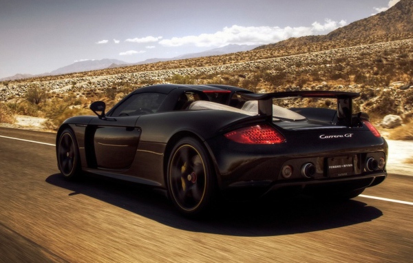 Черный автомобиль мчится по дороге