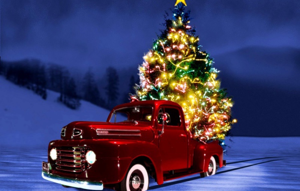 Красная машина на фоне ёлки на рождество