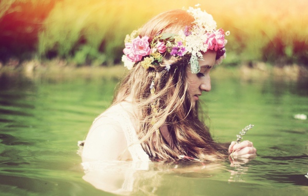 Девушка купается с венком на голове