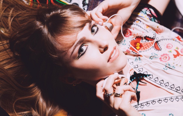 Девушка лежит с наушниками