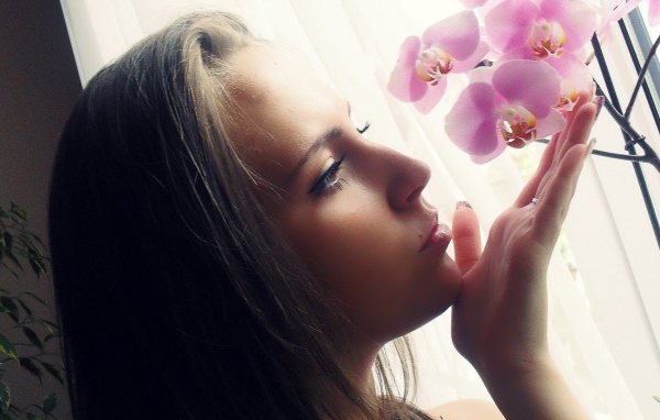 Девушка смотрит орхидею