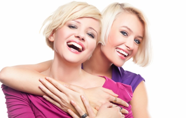 Две белозубые девушки смеются