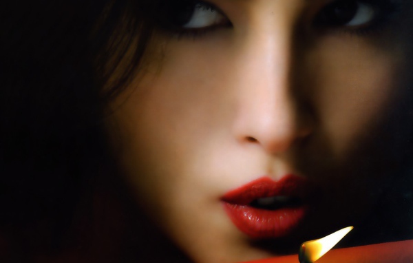 Брюнетка задувает свечу