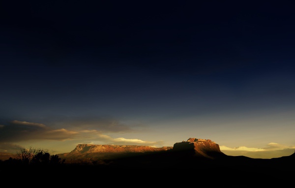 Солнце на закате освещает гору