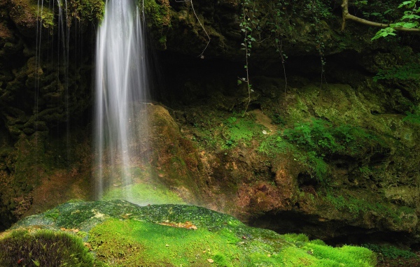 Струи воды на зеленые камни