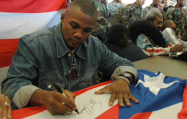 Боксер Феликс Тринидад подписывает флаг