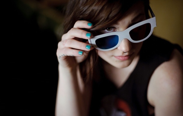 Девушка брюнетка в очках и с пирсингом в носу