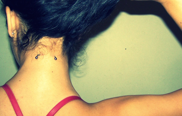 Девушка брюнетка с пирсингом в шее