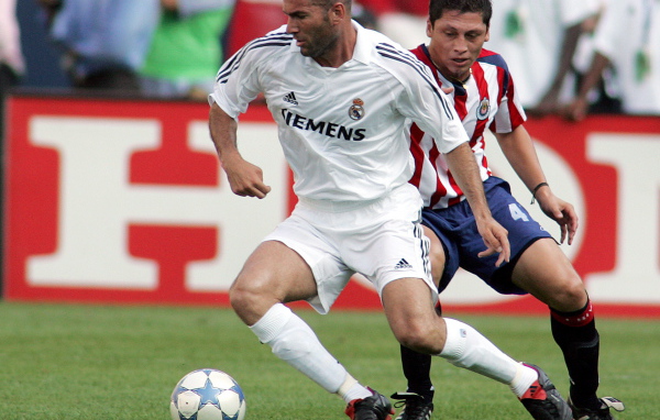 Легенда футбола Зинедин Зидан передавая мяч