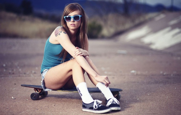 Девушка со скейтом и в очках