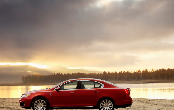 Красный автомобиль на берегу реки