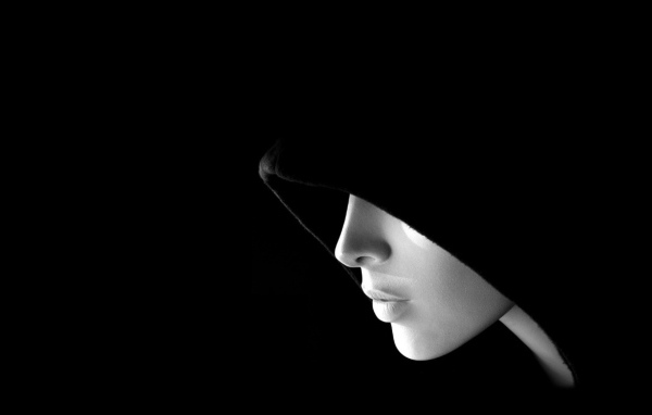 Лицо в капюшоне на черных обоях