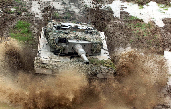 Танк в маскировке едет по грязи