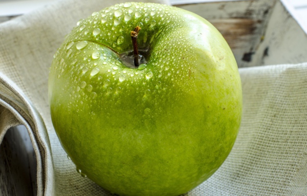 Влажное яблоко на холсте