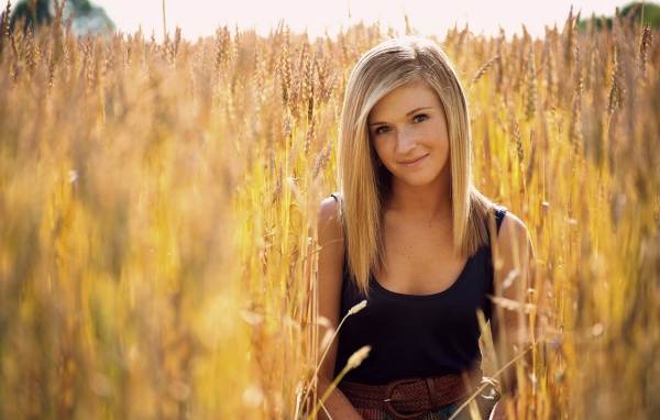 Девушка с веснушками среди пшеницы