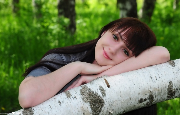 Девушка улыбается в лесу