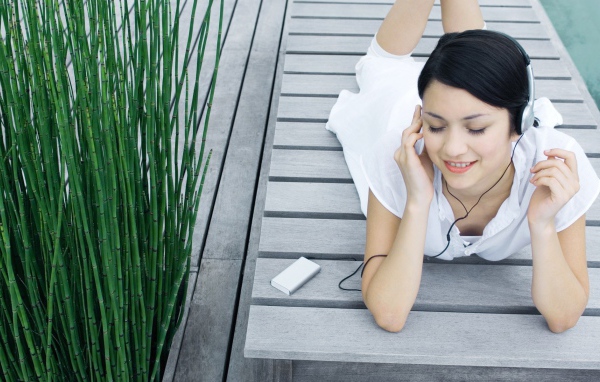 Девушка в белом платье слушает музыку