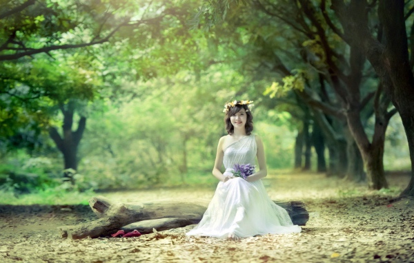 Девушка сидит на бревне