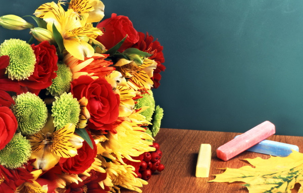 Букет и мелки на столе в День знаний 1 сентября