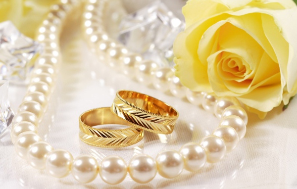 Свадебные кольца и жёлтая роза