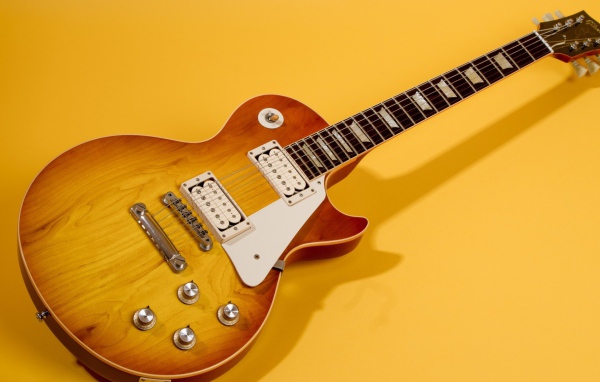 Гитара с тенью на жёлтом фоне