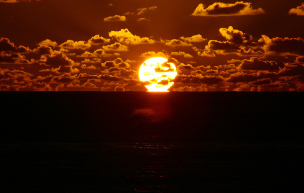 Солнце между небом и морем