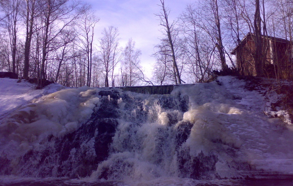 Замерзший водопад и хижина лесника