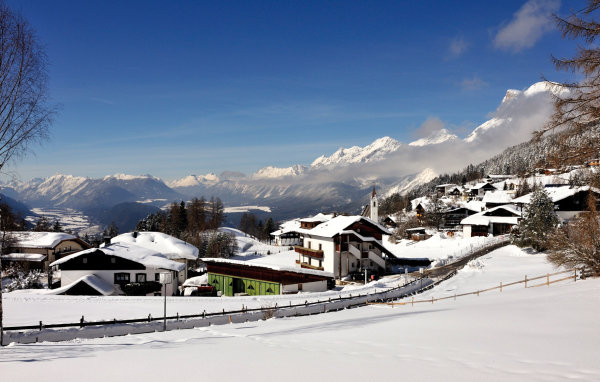 Дома на фоне гор на курорте Зеефельд, Австрия