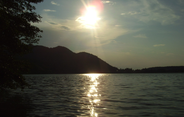 Солнце над водой озера Клопайнер Зее, Австрия