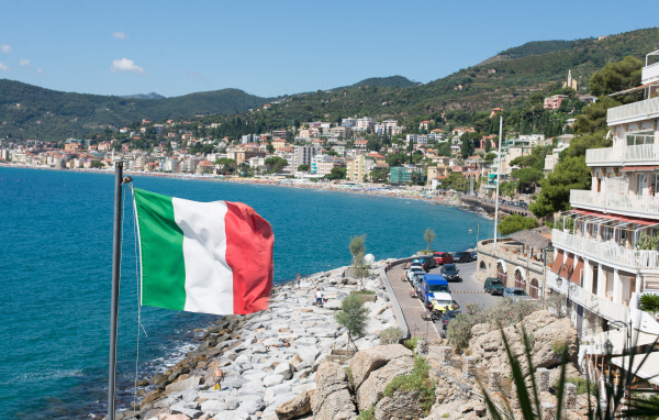 Флаг на фоне пляжа на курорте Алассио, Италия