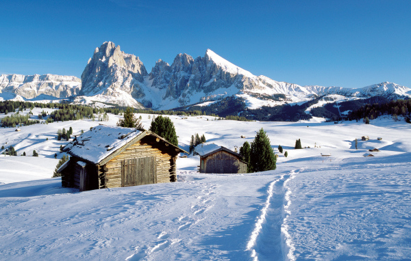 Дома на фоне гор на горнолыжном курорте Валь Гардена, Италия